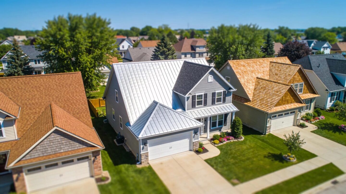 Aerial view of diverse residential roofs including asphalt shingles and metal roofs in a Southern Wisconsin neighborhood