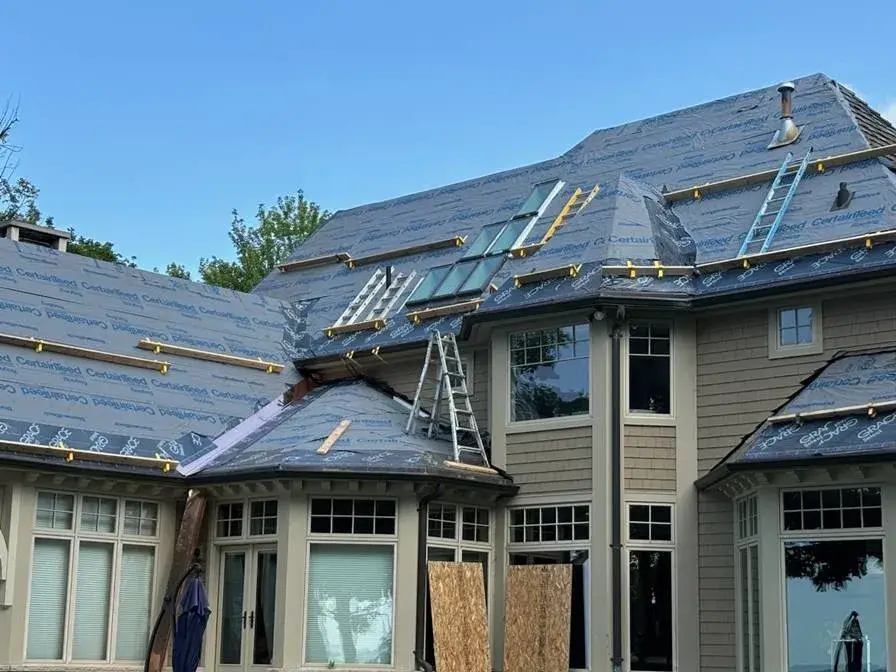 A roofing professional inspecting a flat roof for early issue detection and timely repairs, promoting proactive maintenance.